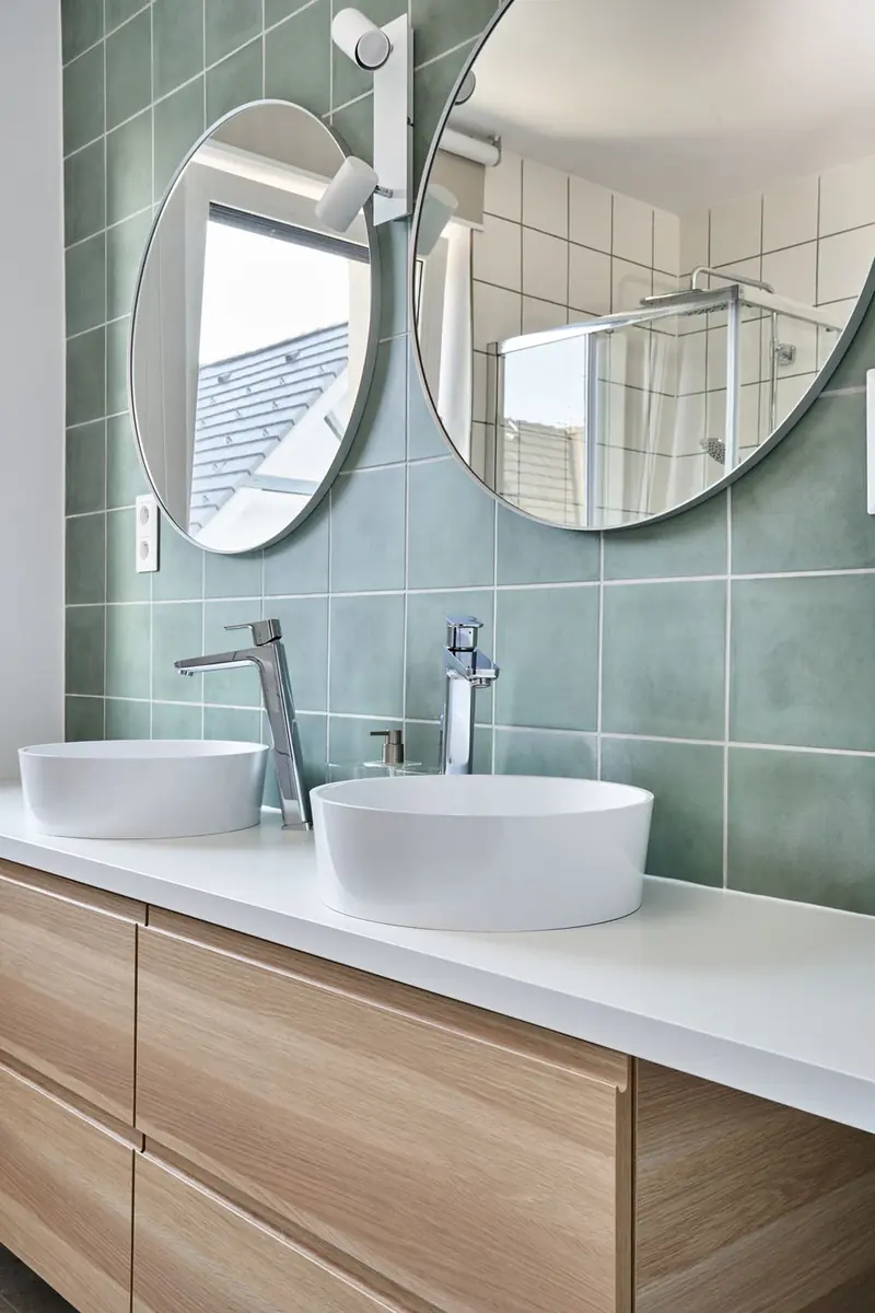 Koupelna se dvěma umyvadly a kulatými zrcadly